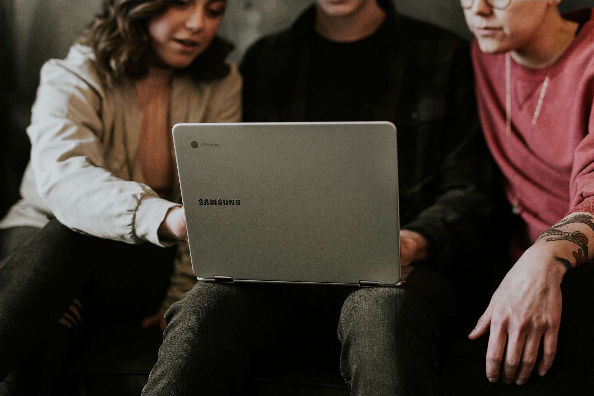 Three AI experts looking at laptop at AI staffing and talent solutions