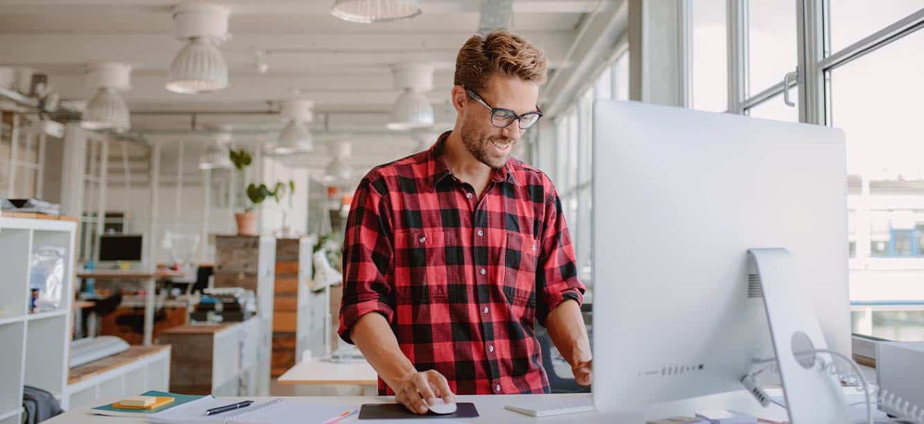 Creative professional standing at computer looking for creative jobs in Los Angeles