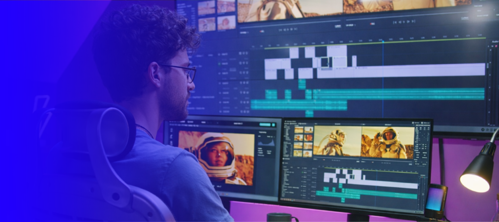 AI expert working at a desk, typing on a keyboard while viewing a video production platform on a widescreen monitor, with a blue gradient overlay on the left side of the image.